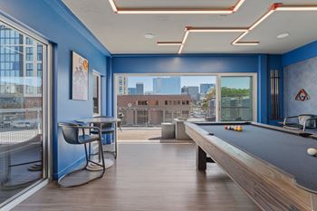 A room with a pool table and a chair.